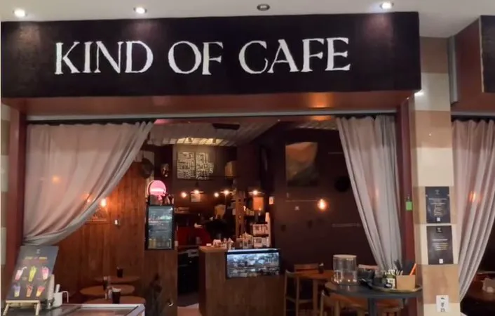 Kind of Cafe ieeja T/C Liiba ar izkārtni un gaišiem aizkariem